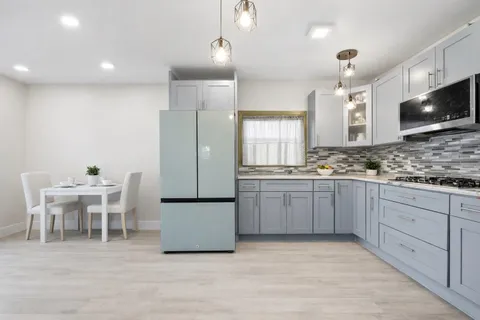 a kitchen with granite countertop a refrigerator stove and microwave