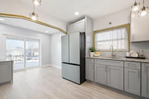 a kitchen with stainless steel appliances a refrigerator sink cabinets and wooden floor