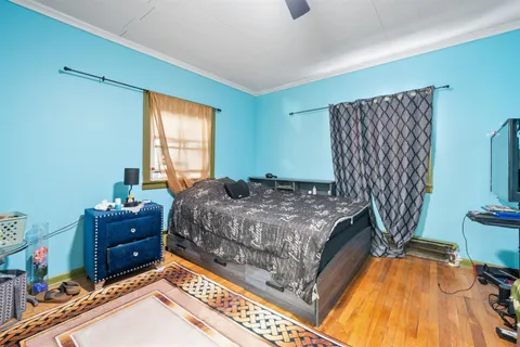 a bedroom with a bed and a flat tv screen on dresser