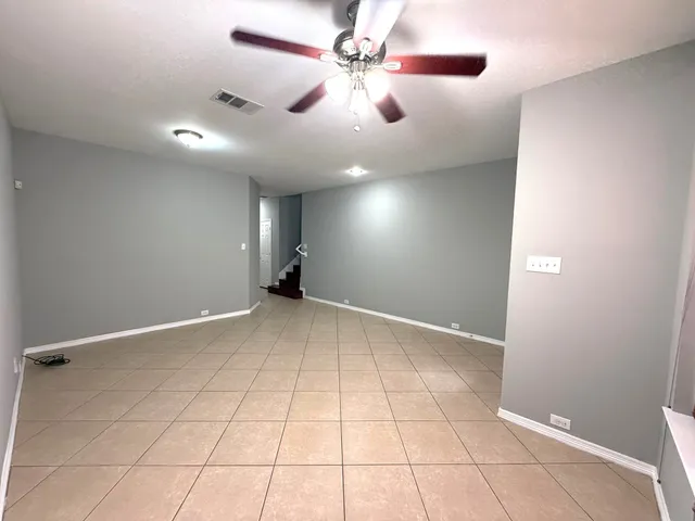 a view of an empty room and a ceiling fan