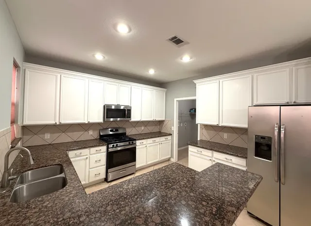 a kitchen with stainless steel appliances granite countertop a sink and a stove
