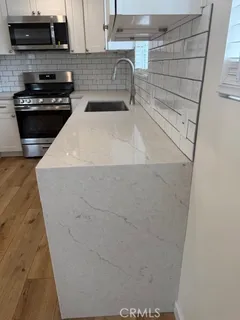 a kitchen with a sink and a stove top oven
