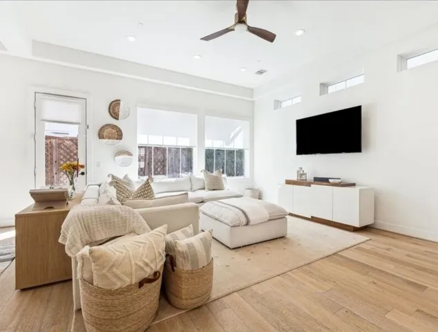 a living room with furniture a flat screen tv and a large window