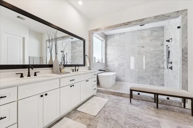 a spacious bathroom with a double vanity sink a toilet a mirror and shower