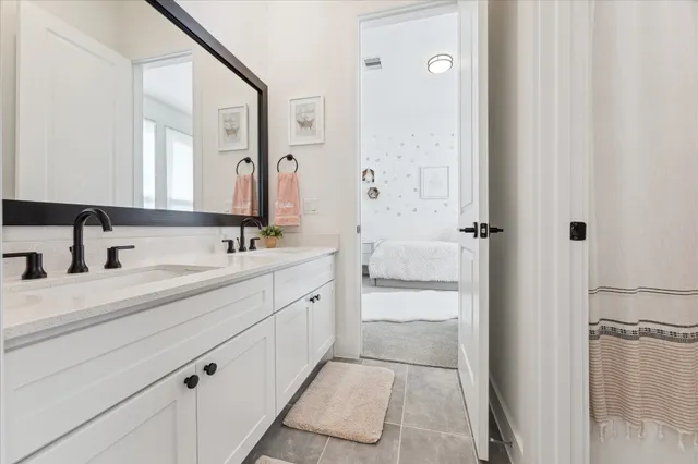 a bathroom with a double vanity sink a mirror and a shower