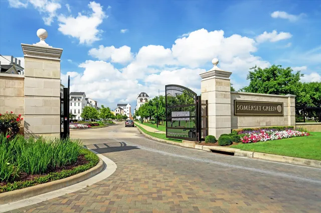 a sign board with flower plants and wooden fence