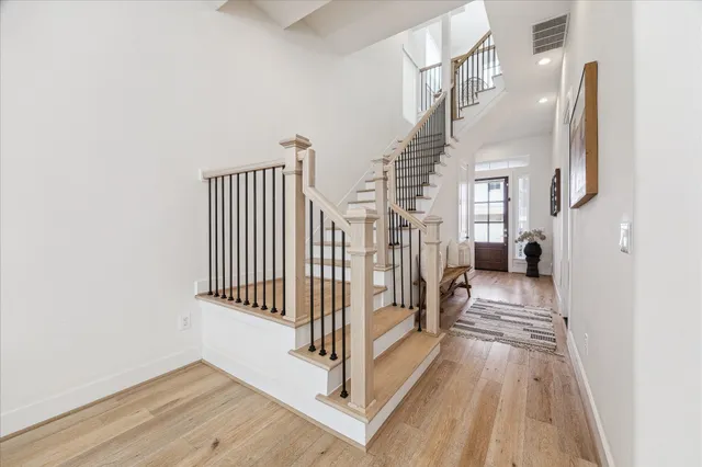 a view of a hallway with wooden floor and stairs