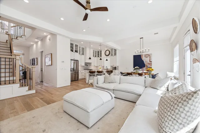 a living room with furniture a rug and kitchen view