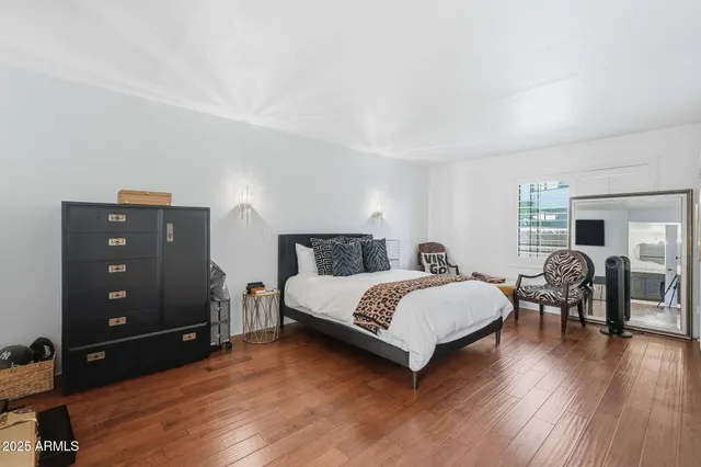 a bedroom with a bed and wooden floor