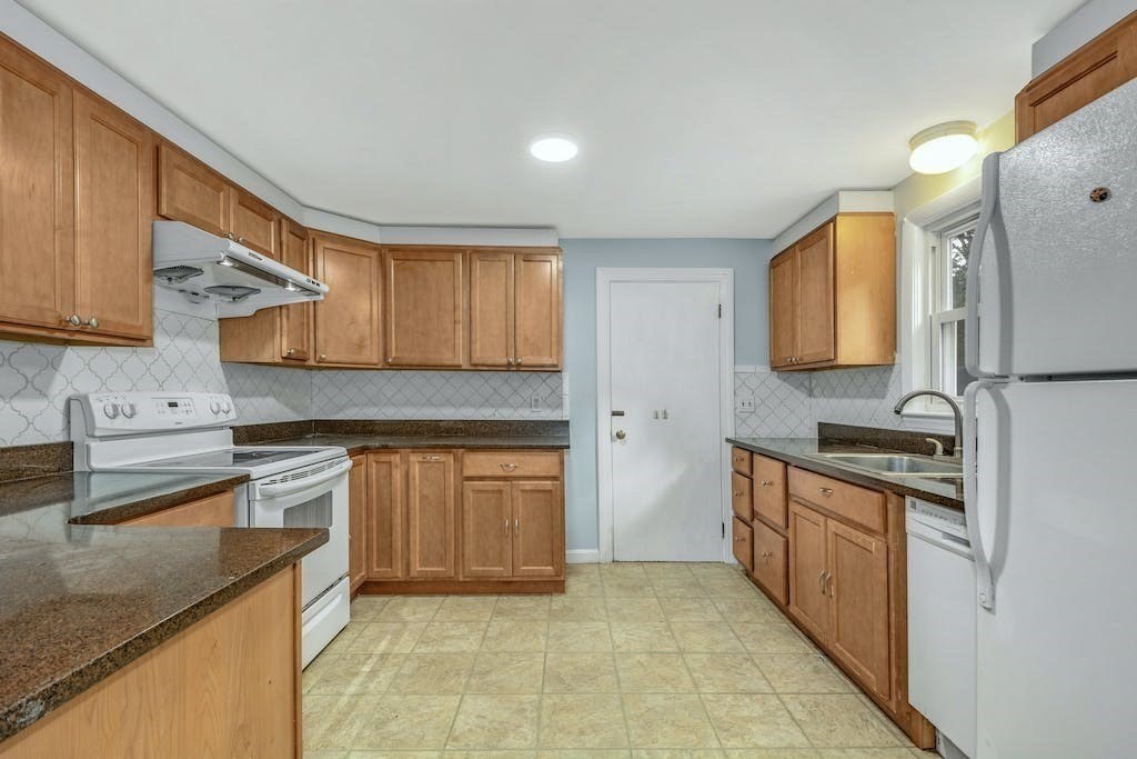 30 Old Marlboro Road Maynard, MA 01754 - Photo 8 of 34 a kitchen with stainless steel appliances granite countertop a sink stove and refrigerator