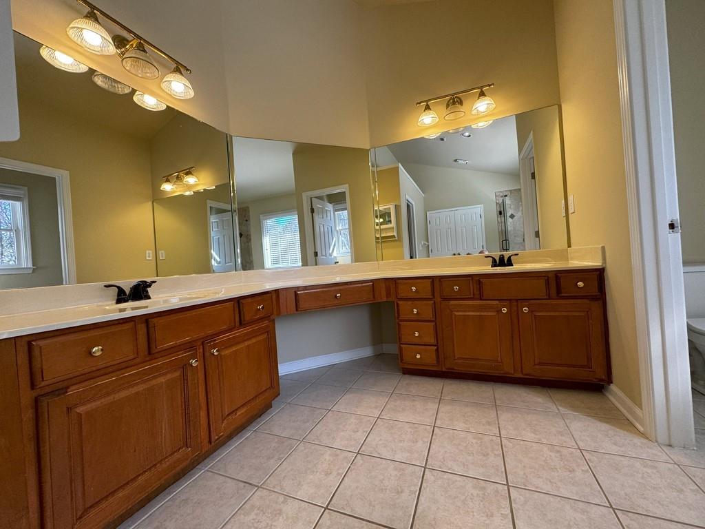 2620 Springmonte Place Cumming, GA 30041 - Photo 23 of 67 a spacious bathroom with a vanity a sink a mirror and a toilet