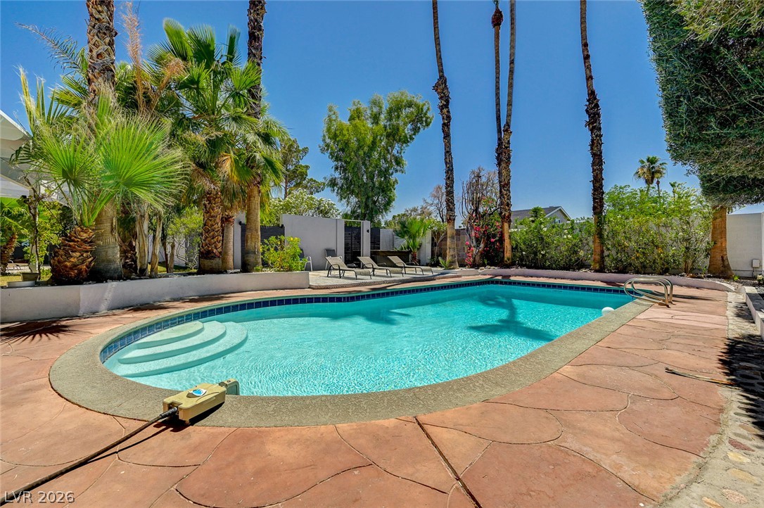 4153 Woodcrest Road Las Vegas, NV 89121 - Photo 52 of 58 An inviting backyard oasis offers a sparkling in-ground pool and ample space for lounging beneath the sun.