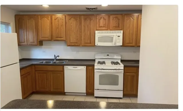a kitchen with a stove cabinets and a refrigerator