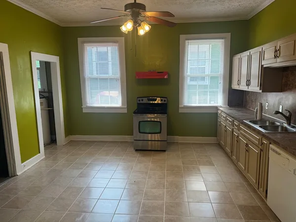 a kitchen with kitchen island granite countertop a stove a sink and a refrigerator
