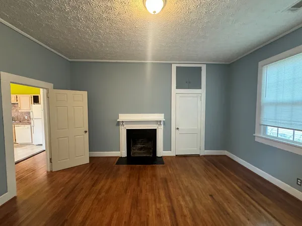 an empty room with windows and fireplace