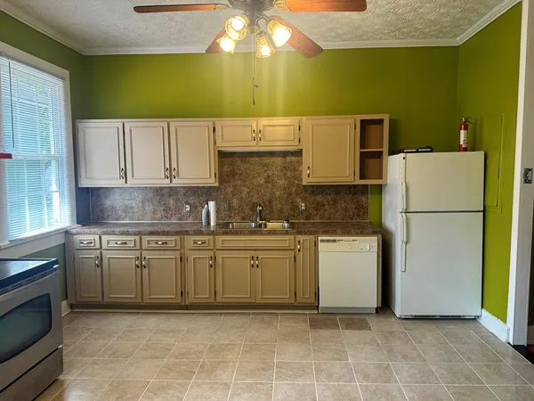 a kitchen with a refrigerator sink stove and cabinets