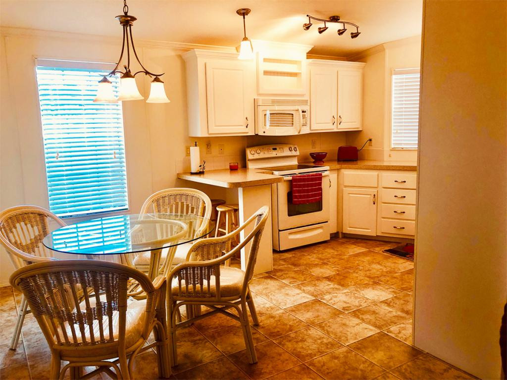57 Temple Lane Naples, FL 34114 - Photo 13 of 18 a kitchen with stainless steel appliances a stove a sink a chair and dining table