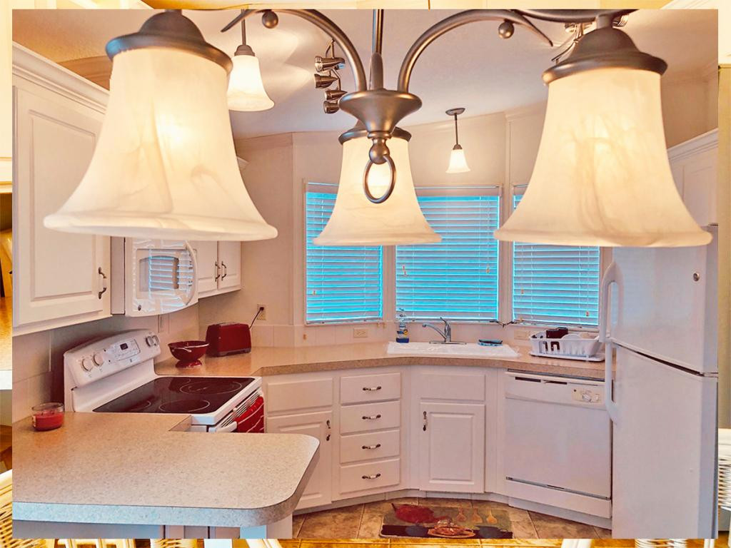 57 Temple Lane Naples, FL 34114 - Photo 8 of 18 a kitchen with a sink a stove and white cabinets