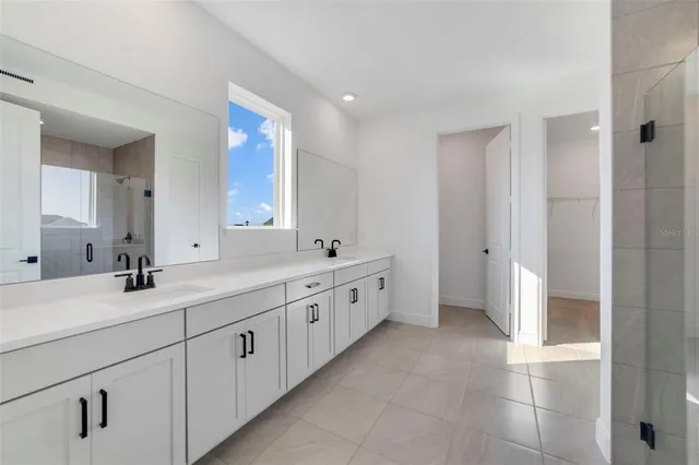 a spacious bathroom with a double vanity sink and a mirror