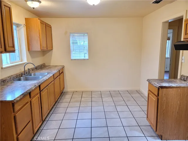 a kitchen with a sink a stove cabinets and a window
