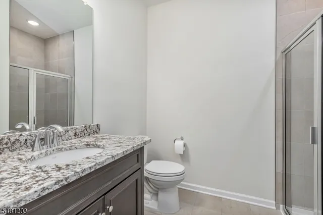 a bathroom with a granite countertop sink toilet and mirror