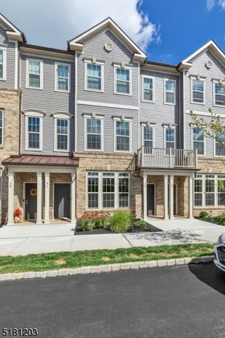 a front view of a residential apartment building with a yard and plants