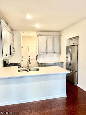 a view of a kitchen with a sink and dishwasher with wooden floor