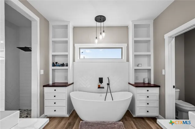 a spacious bathroom with a double vanity sink a mirror and a bathtub