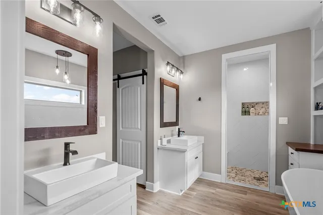 a bathroom with a sink a toilet a mirror and shower