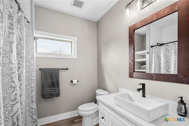 a bathroom with a sink mirror vanity and toilet