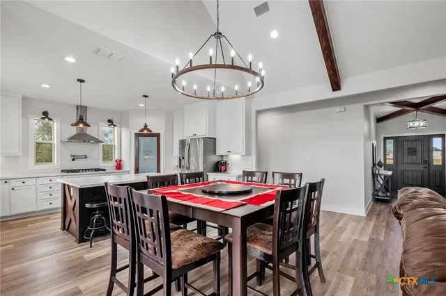 a view of a dining room with furniture and chandelier