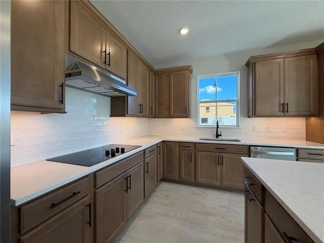a kitchen with stainless steel appliances granite countertop a sink stove and cabinets