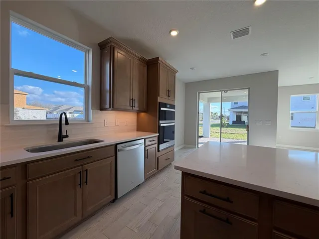a kitchen with kitchen island a sink stove and cabinets