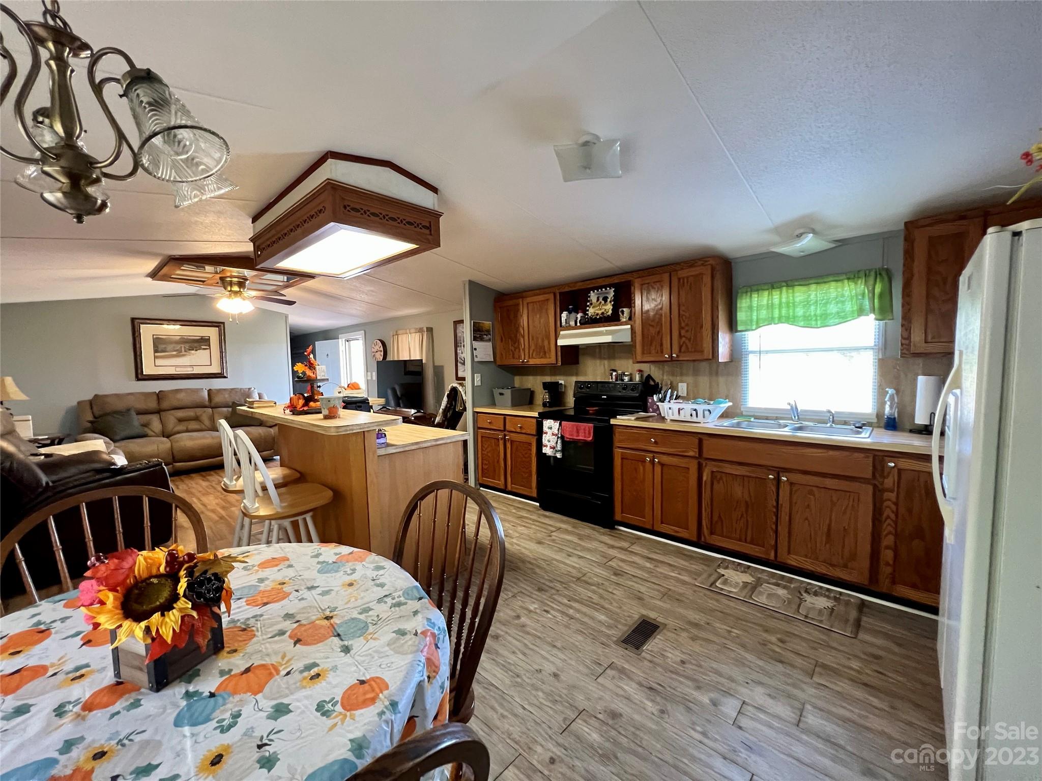 1508 Scenic View Road Hickory Grove, SC 29717 - Photo 8 of 24 a kitchen with stainless steel appliances kitchen island granite countertop a stove top oven a sink a dining table and chairs with wooden floor