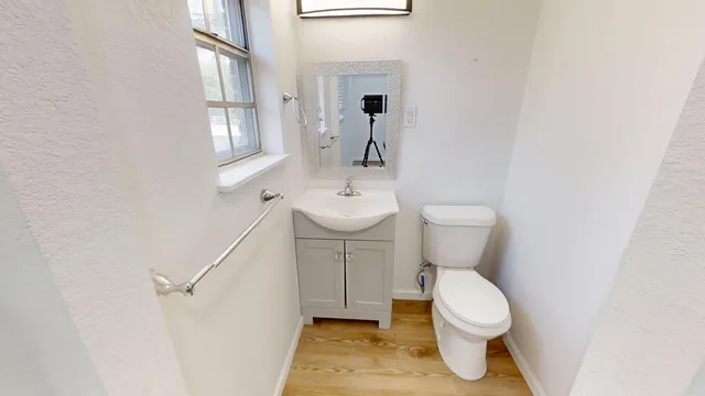 a bathroom with a toilet sink and mirror