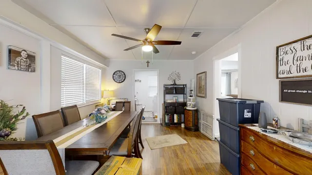 a view of a dining room with furniture a rug and wooden floor