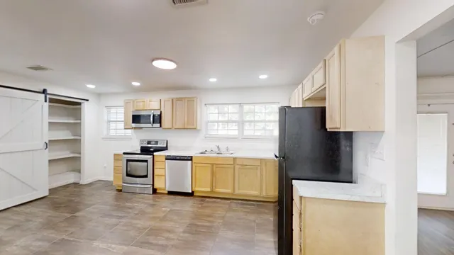 a kitchen with stainless steel appliances a stove a refrigerator sink and cabinets