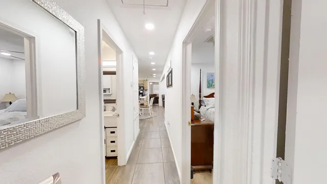 a view of a hallway with wooden floor and windows