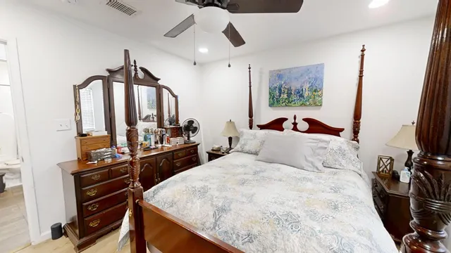 a bedroom with a bed and a flat tv screen on a dresser