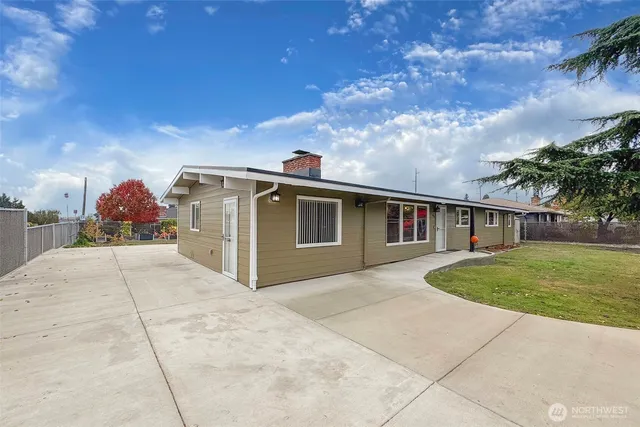 a front view of a house with a garden and mountain view