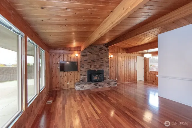 a view of a room with wooden floor a fireplace and window