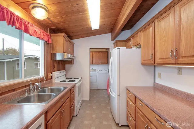 a kitchen with granite countertop a sink a counter top space stainless steel appliances and cabinets