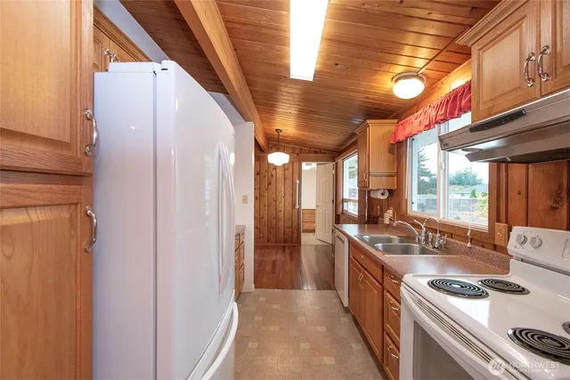 a kitchen with stainless steel appliances granite countertop a sink a stove and a refrigerator