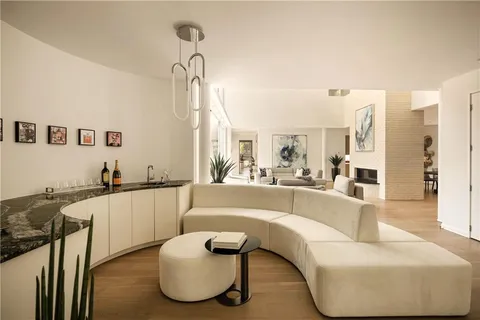 a living room with furniture fireplace and a large window