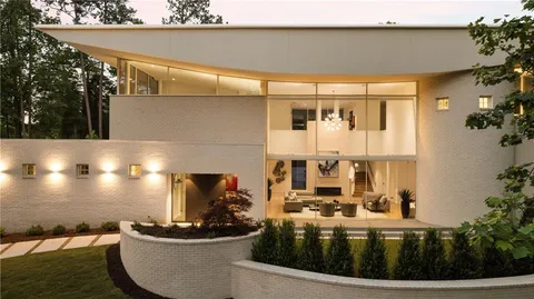 a living room with furniture a rug and a floor to ceiling window