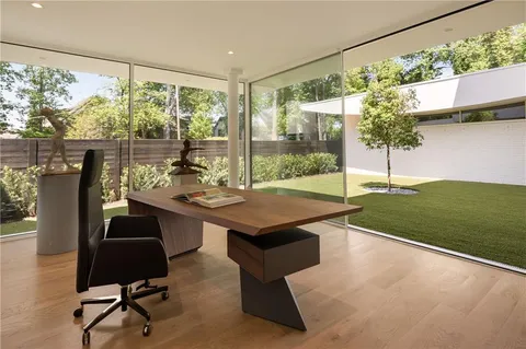 a bedroom with a bed and large windows