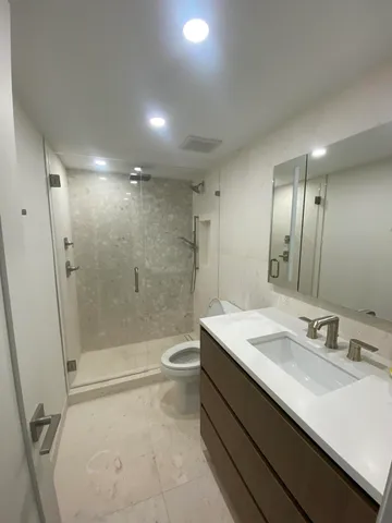 a bathroom with a sink a toilet and shower