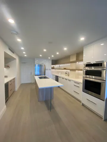 a large kitchen with stainless steel appliances granite countertop a stove a sink and a microwave