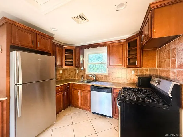a kitchen with stainless steel appliances granite countertop a refrigerator and a sink