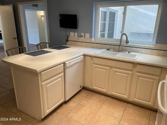 an empty room with chandelier fan and windows